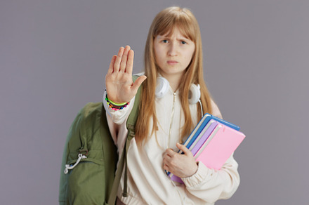 unhappy trendy teen girl with backpack showing stop gesture, a School & Education Photo by Alliance Images