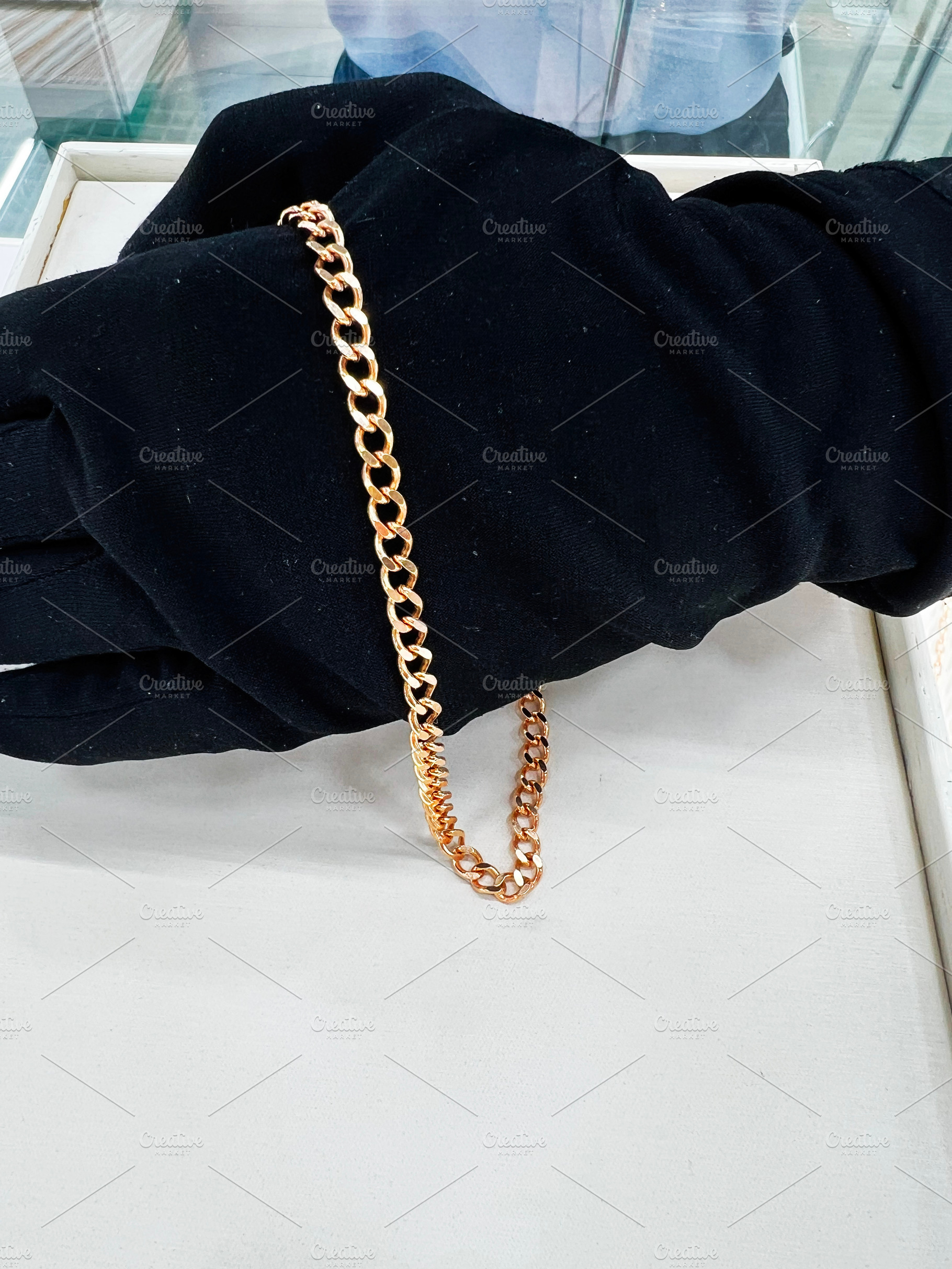 Elegant golden chain displayed on black fabric in a professional setting, a Photo by AS photostudio