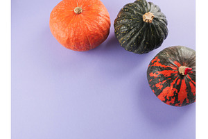 Three colorful pumpkins on purple