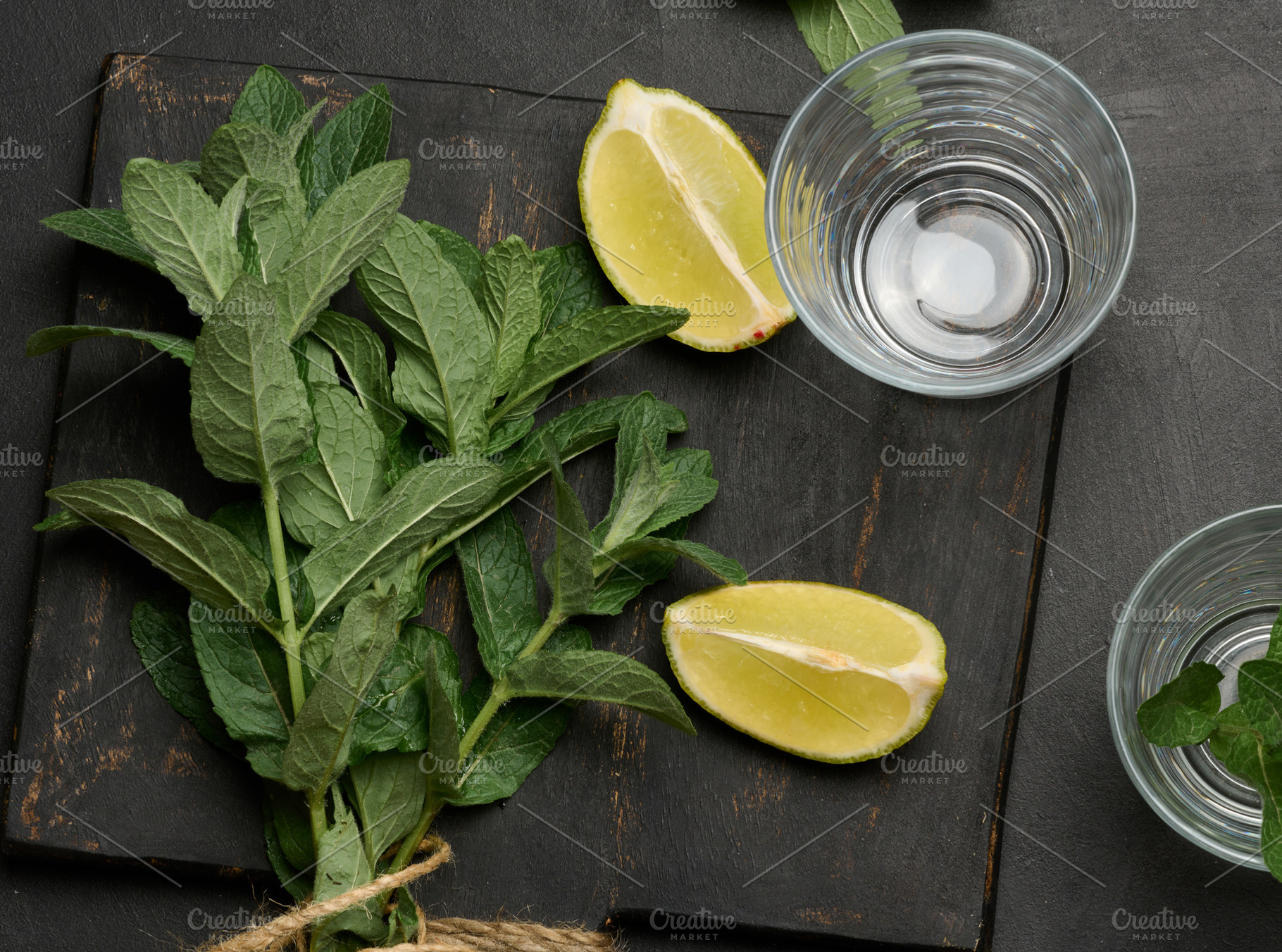 Bunch of fresh green mint, lime slices, glasses, top view. Cockt, a Food & Drink Photo by ndanko
