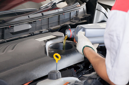 Servicing mechanic pouring new oil lubricant into the car engine stock photo, an Industrial Photo by Twinster Photo