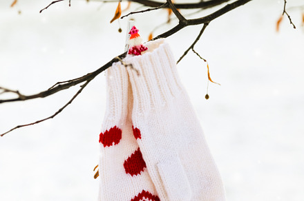 White mittens with red hearts decor are hanging on a tree branch featuring, a Holiday Photo by Ekaterina_Markelova