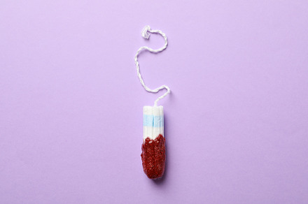 Used tampon on violet background, space for text, a Health & Medical Photo by AtlasStudio