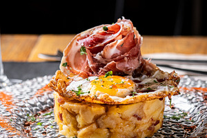 Traditional Spanish potato omelette with Iberian ham and crispy pork rind serve, a Food & Drink Photo by etorres69