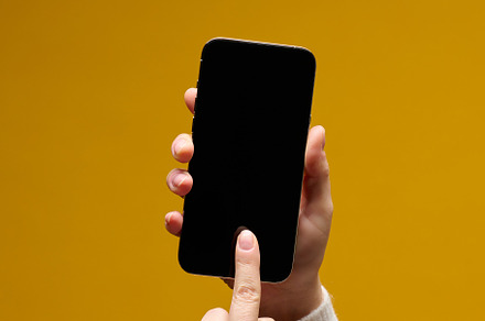 female hand holding smartphone with blank black screen on yellow, a Technology Photo by ndanko