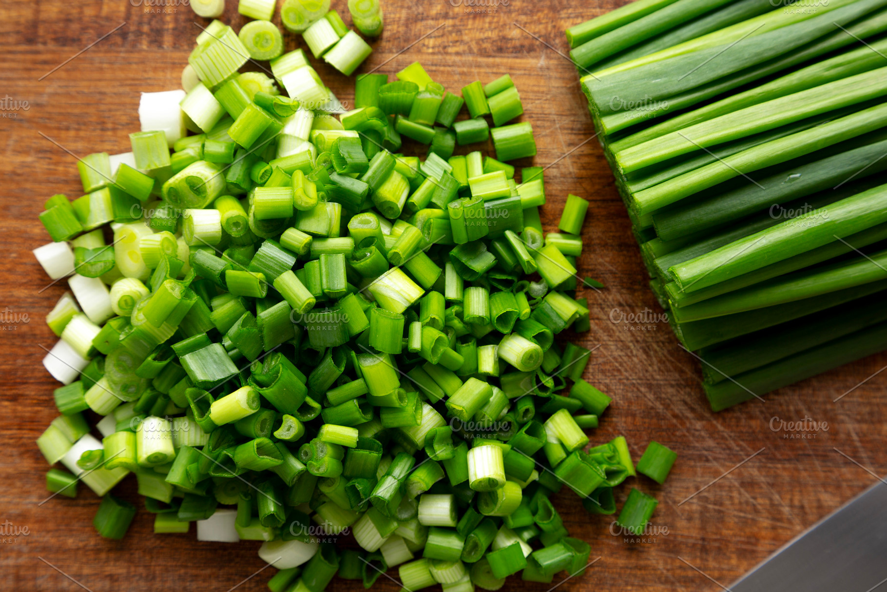 Organic Cut Green Onion Scallions on a Wooden Board, top view., a Food & Drink Photo by LiudmylaChuhunova
