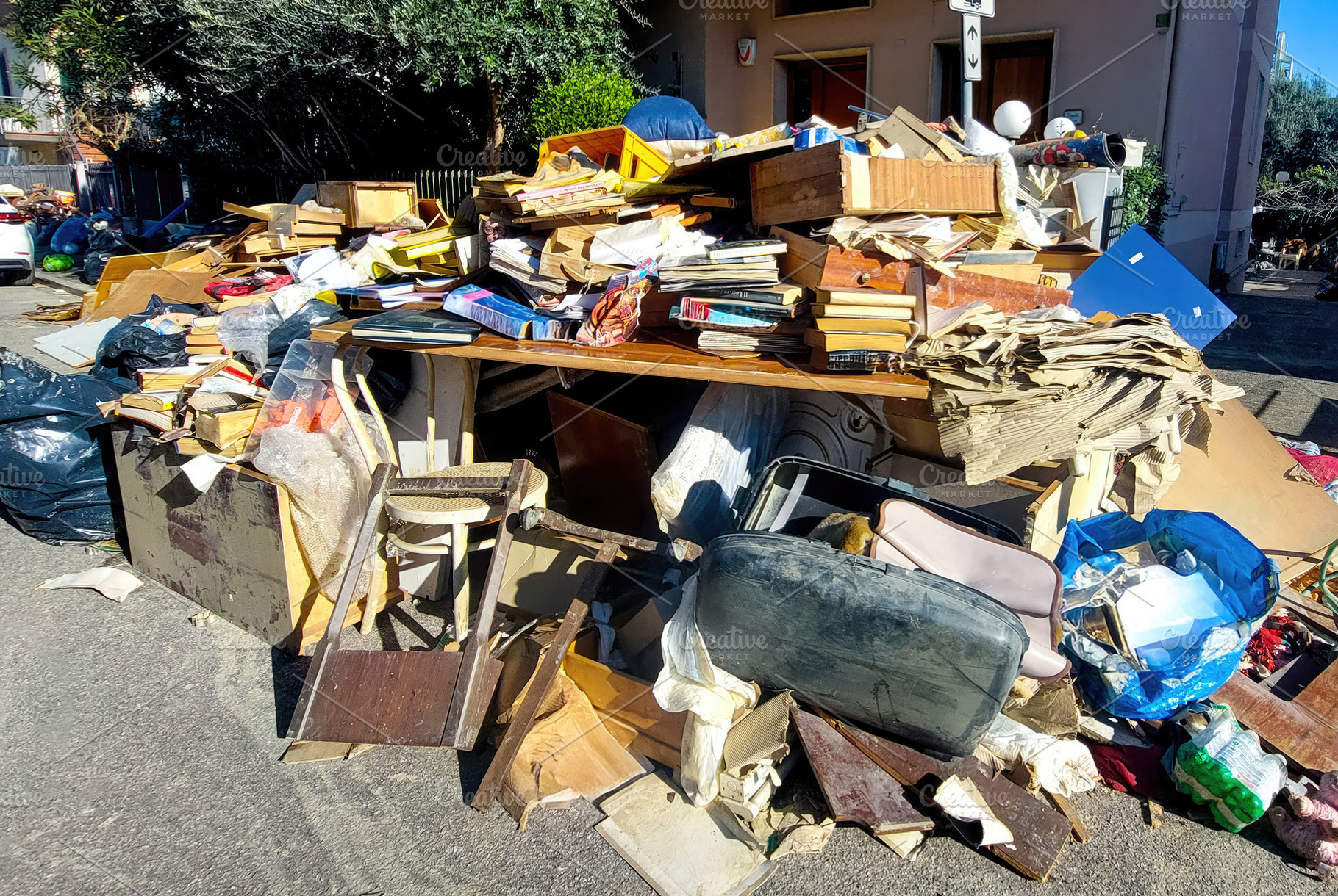 Pile of debris and damaged furniture left on the street after a flood, an Architecture Photo by Antonio Gravante Market