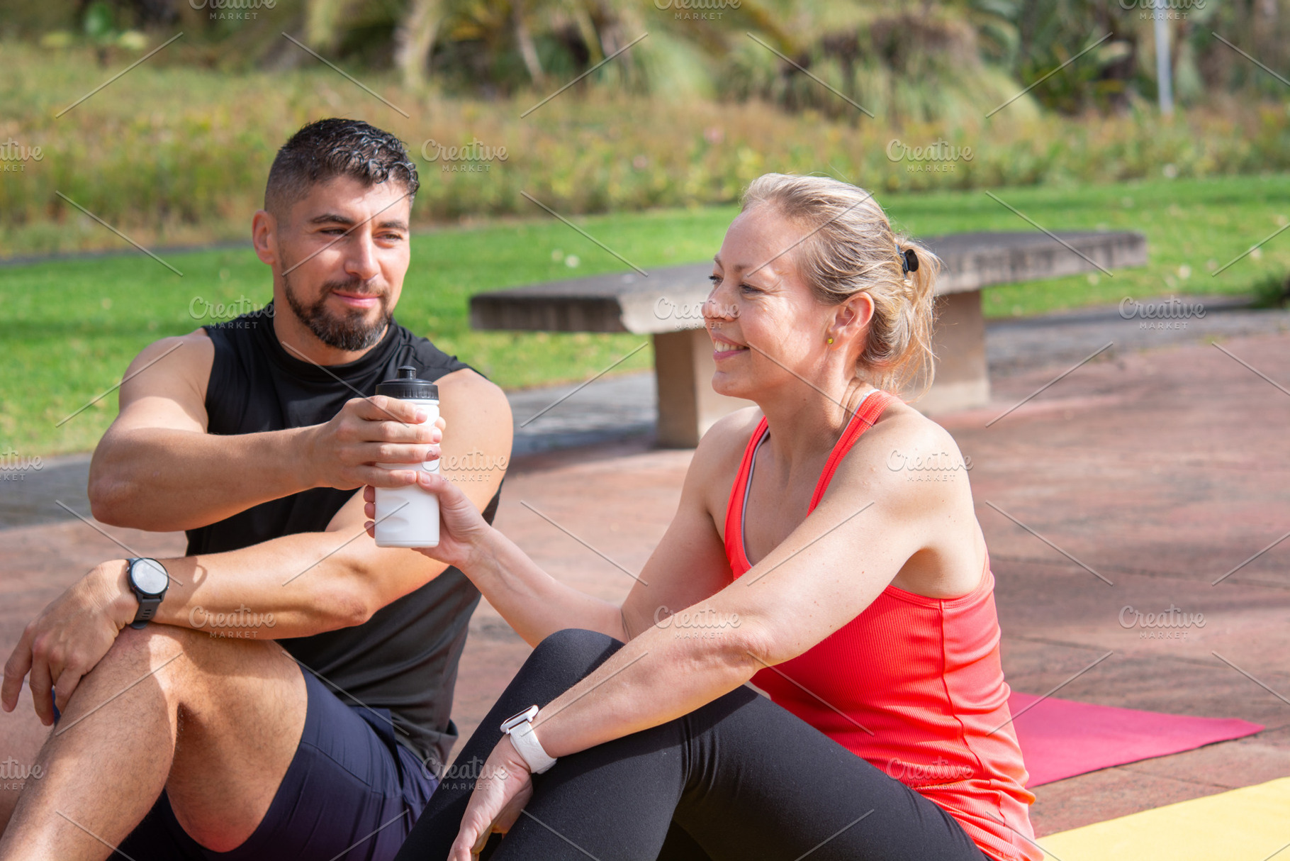 Two Friends Sharing Water During Outdoor Fitness Workout, a Person Photo by etorres69