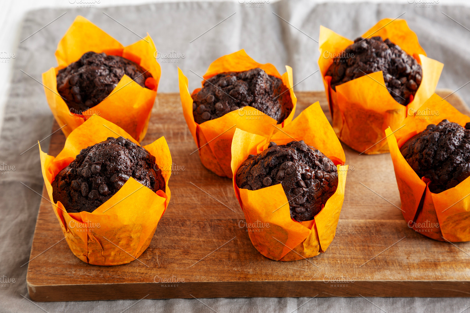 Homemade Chocolate Chip Muffins on a wooden board, side view., a Food & Drink Photo by LiudmylaChuhunova