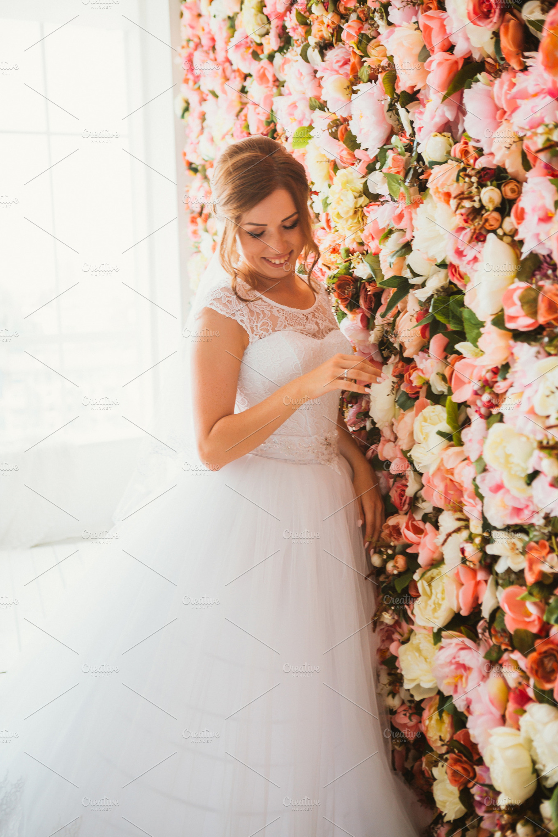 Beautiful bride on the background of a wall of flowers featuring wall, a Person Photo by ruslan117