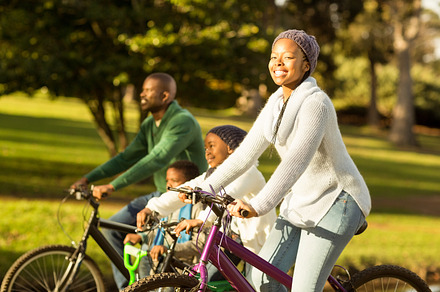 Side view of a young family doing a bike ride, a Photo by wavebreak