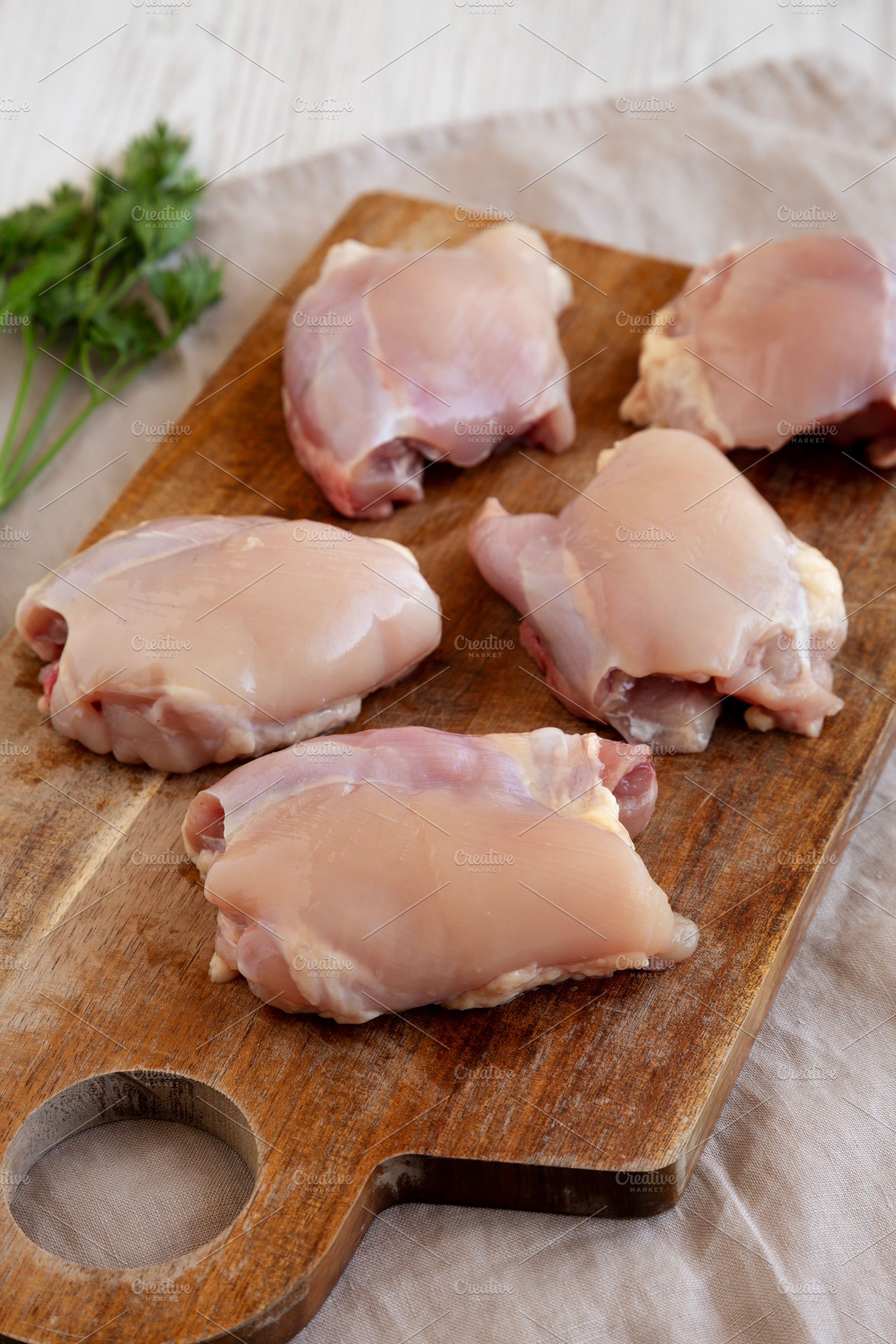 Raw Organic Boneless Skinless Chicken Thighs on a Wooden Board,, a Food & Drink Photo by LiudmylaChuhunova