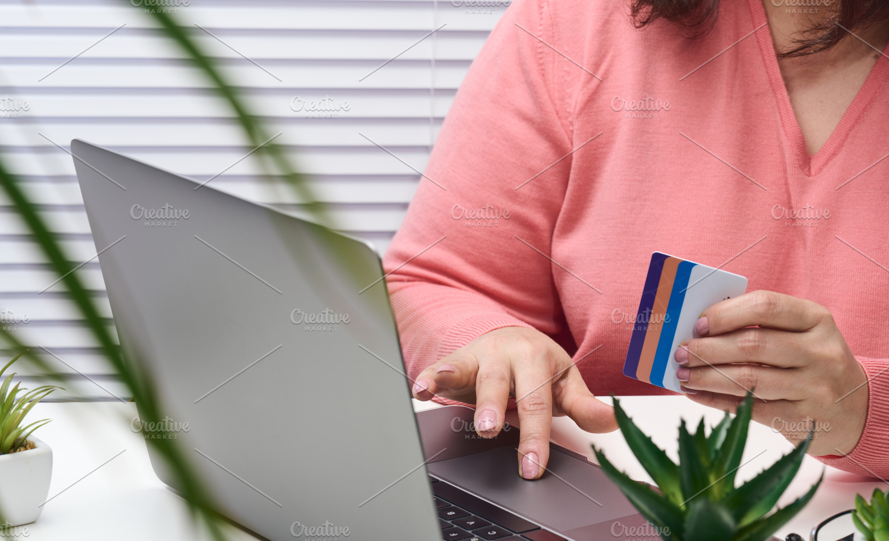 woman in a pink sweater makes purchases online with a laptop, a, a Business Photo by ndanko