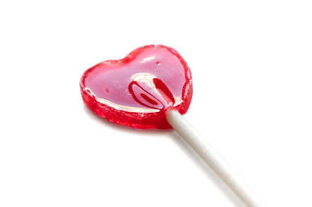 Red heart shaped lollipop isolated on white background, a Food & Drink Photo by GoodGoods