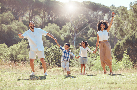 Happy family, kids and walking in nature holding hands, spending vacation time together and bonding. Love, man and woman, children and outdoors park, forest or countryside walk with care and smile., a Photo by Peopleimages.com