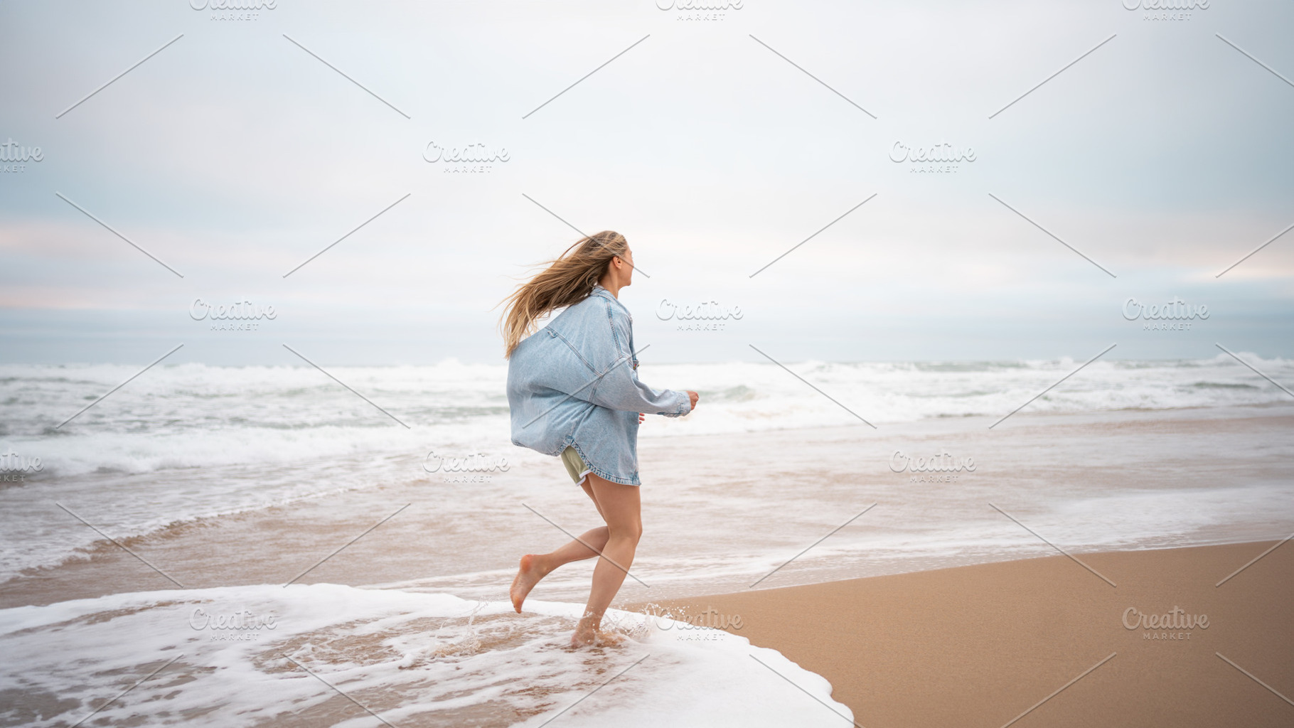 Carefree woman in casualwear running on wet seashore at beach, a Photo by andreonegin market