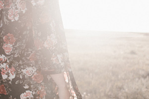 Woman walking in a field at sunset