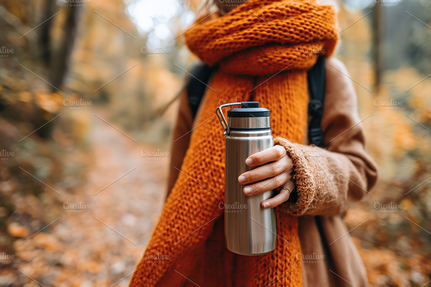 Enjoying a warm drink while walking through the autumn forest with vibrant foli, a Photo by AlyaAnd