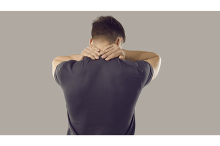 Rear view of tired young man rubbing, a Person Photo by StudioRomantic