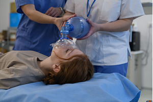 Medical staff applying oxygen mask, a Health & Medical Photo by HalfPoint