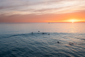 Aerial shot of silhouette people swimming in vast ocean during sunset, a Photo by andreonegin market