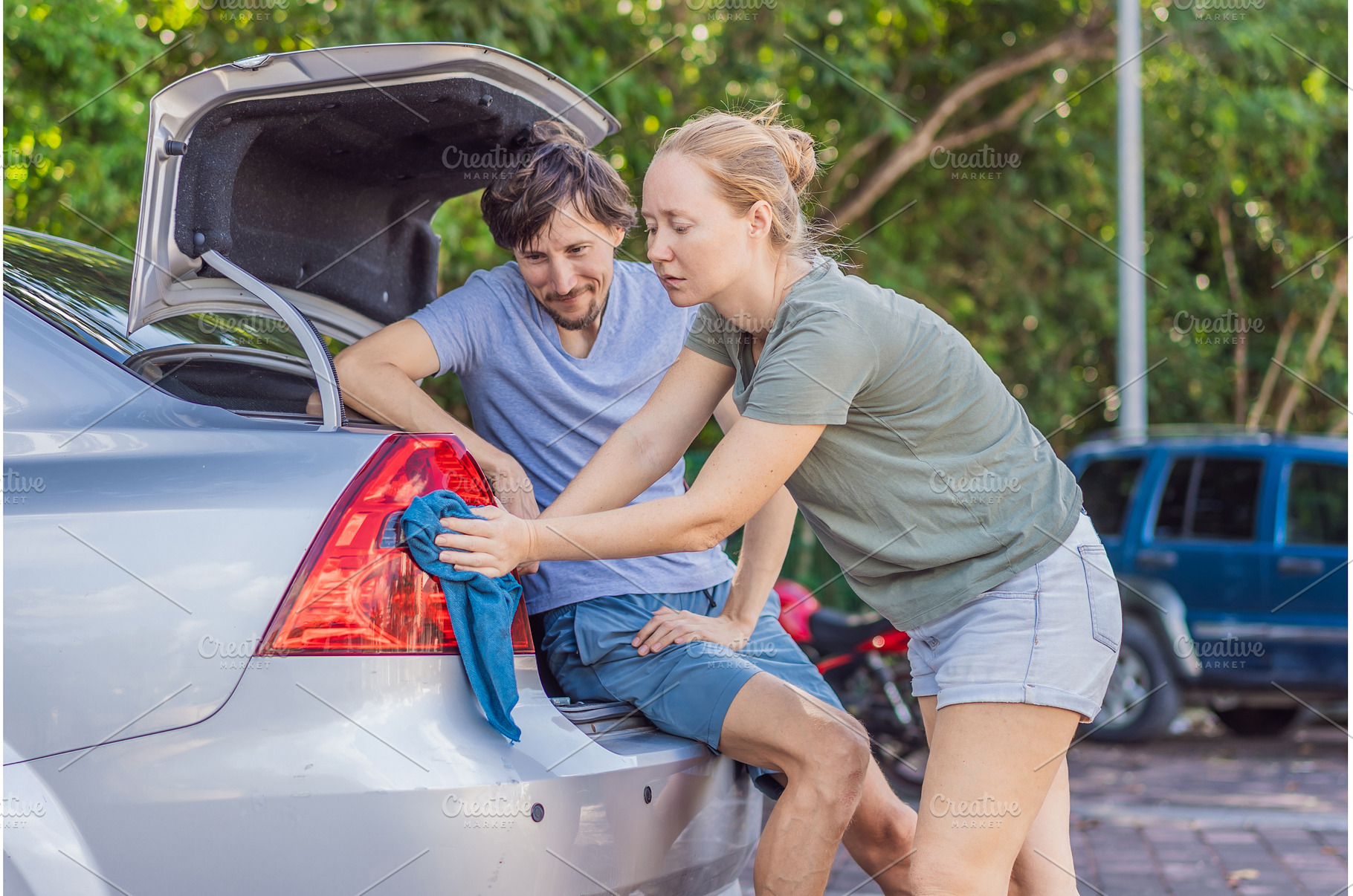 Woman and man washing a car together, a Person Photo by Elizaveta Galitskaya