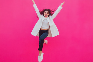 Excited young Woman Jumping in Front, a Photo by Pavel_design