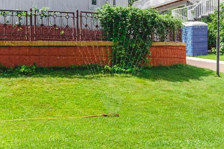 Drip fountain watering system in the garden near the house, a Nature Photo by TanaCh