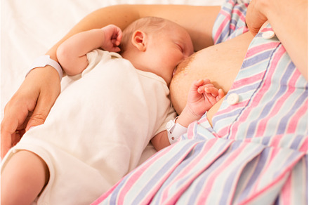 The mom is breastfeeding her newborn, a Health & Medical Photo by oksix
