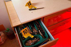 Crime scene investigation with knife and evidence markers in kitchen
