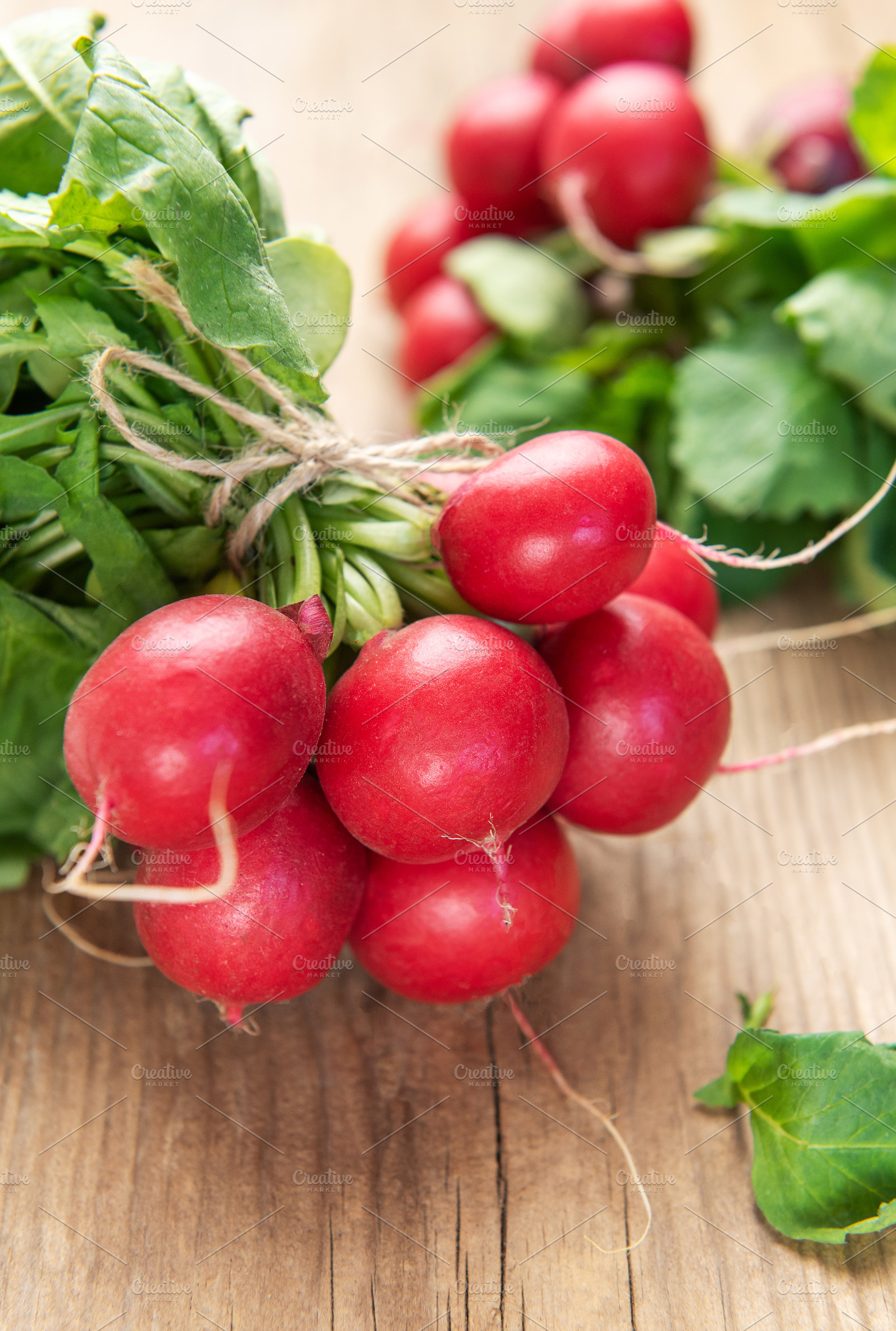Fresh organic radishes with green leaves on wooden table, a Food & Drink Photo by Olena Rudo