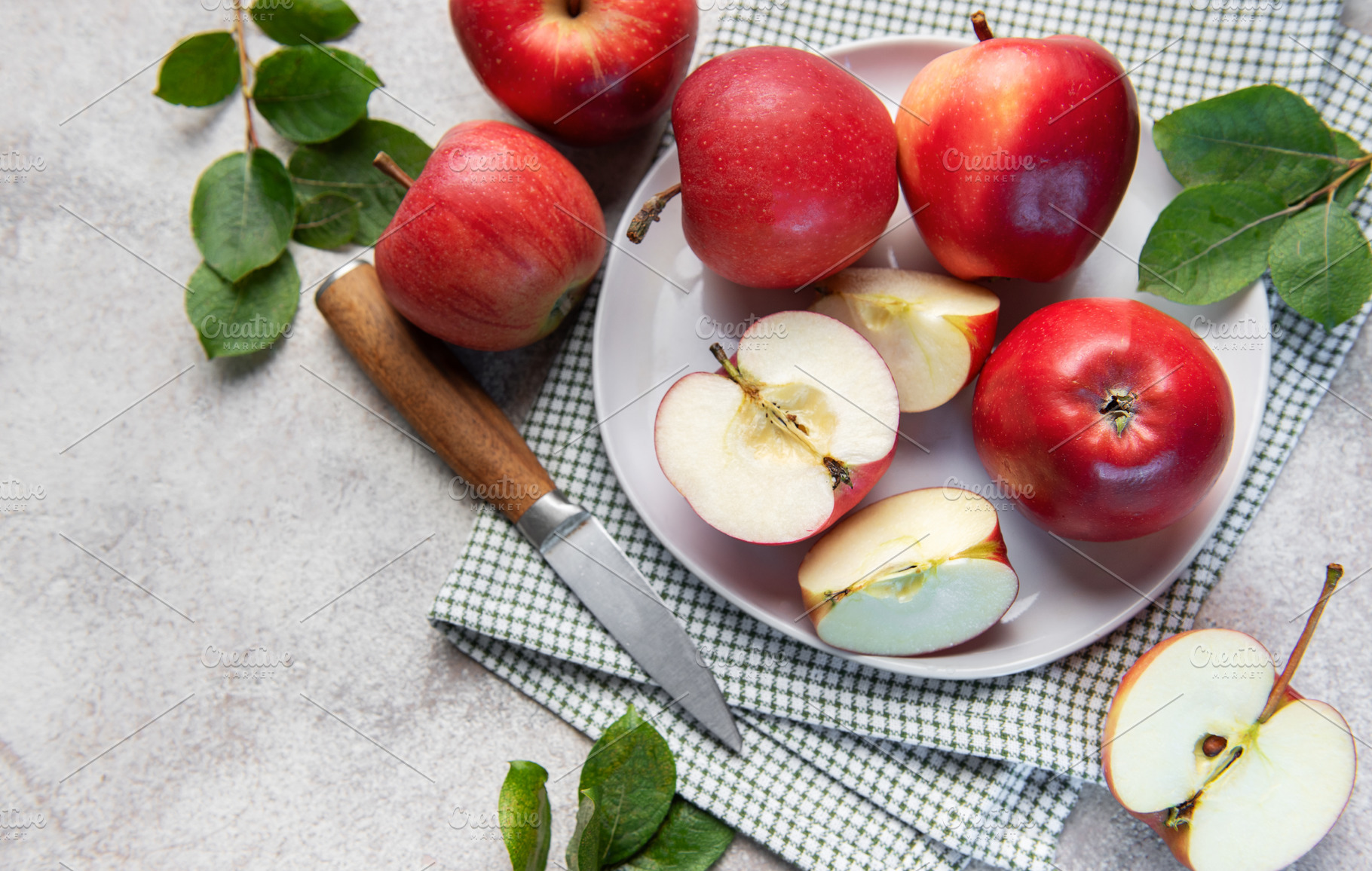Fresh red apples whole and sliced on white plate with green leav, a Food & Drink Photo by Olena Rudo