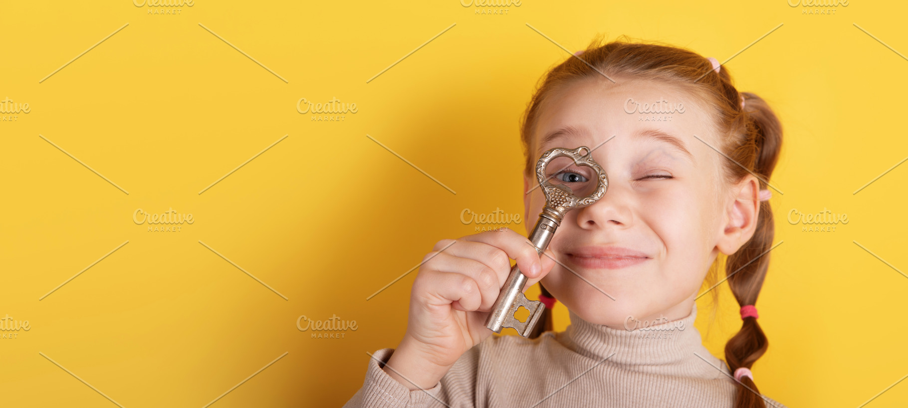 Smiling girl holds an antique key to her eye against a bright ye, a Person Photo by Ales Munt