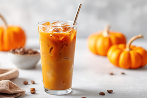 Refreshing iced pumpkin spice beverage served with seasonal decorations, a Food & Drink Photo by AlyaAnd