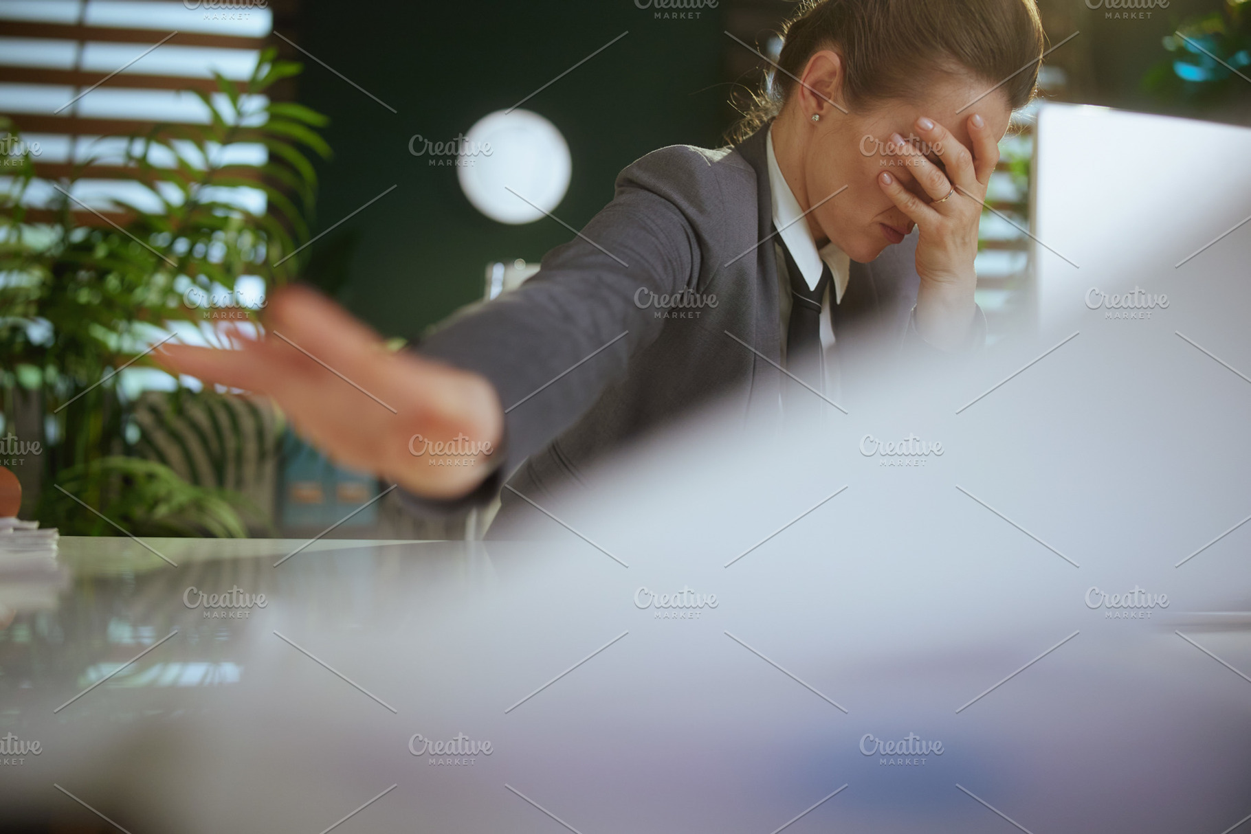 stressed woman worker in green office throwing documents, a Business Photo by Alliance Images