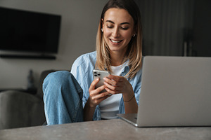 Happy young woman using mobile phone