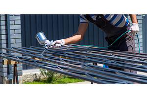 A man spray paints metal. Selective, an Industrial Photo by yanadjana
