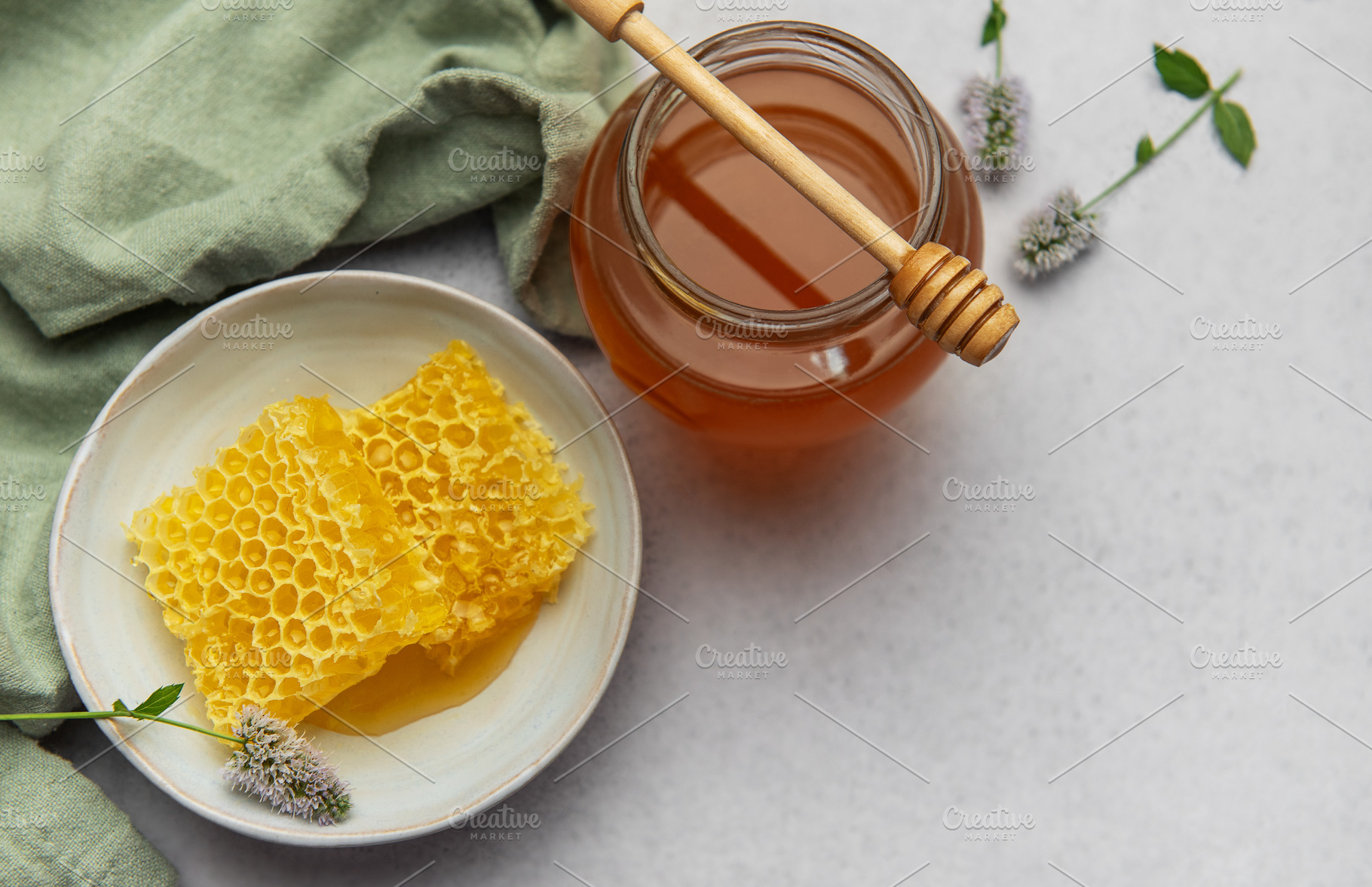 Honeycomb and honey jar with wooden dipper on marble table, a Food & Drink Photo by Olena Rudo