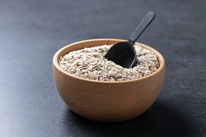 Rolled oats, healthy breakfast cereal oat flakes in bowl on blac, a Food & Drink Photo by etorres69