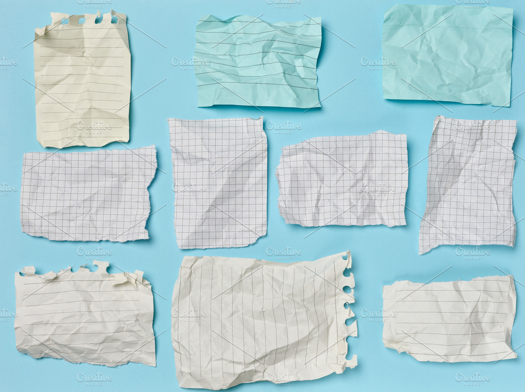 Crumpled and torn squared and lined paper sheets laid out on a b, a Business Photo by ndanko