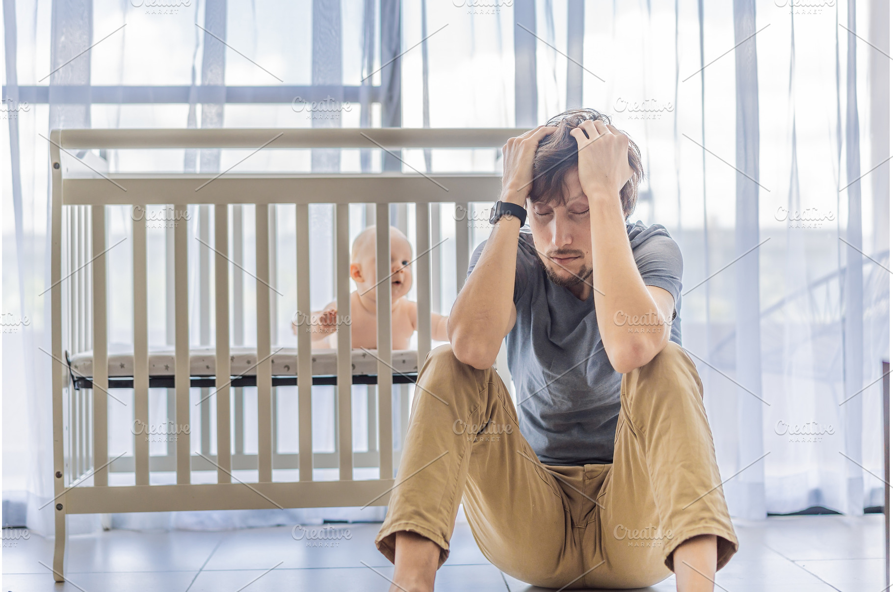 Tired father sitting by baby crib at, a Person Photo by Elizaveta Galitskaya