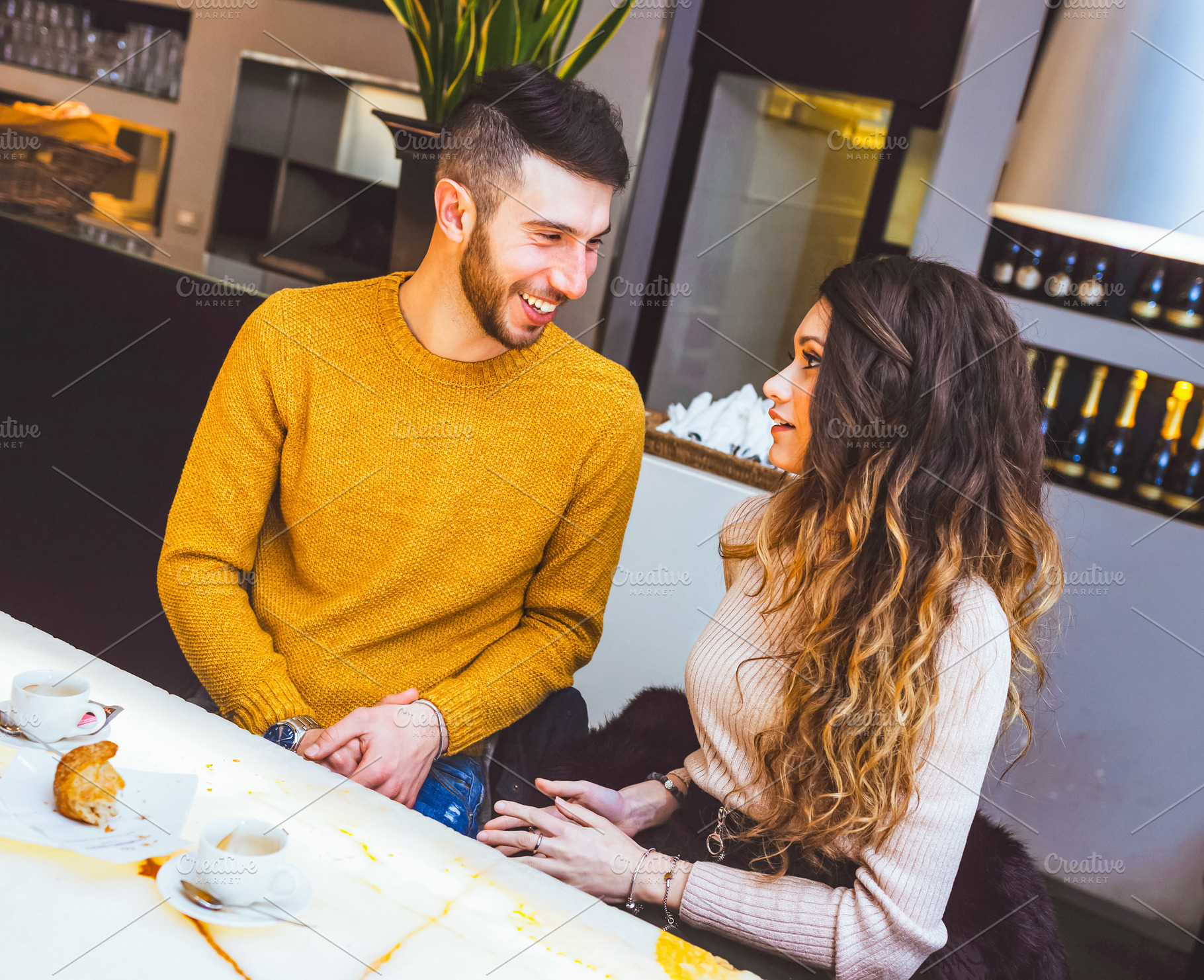 Young couple holding hands and talking in a cafe, a Person Photo by Antonio Gravante Market