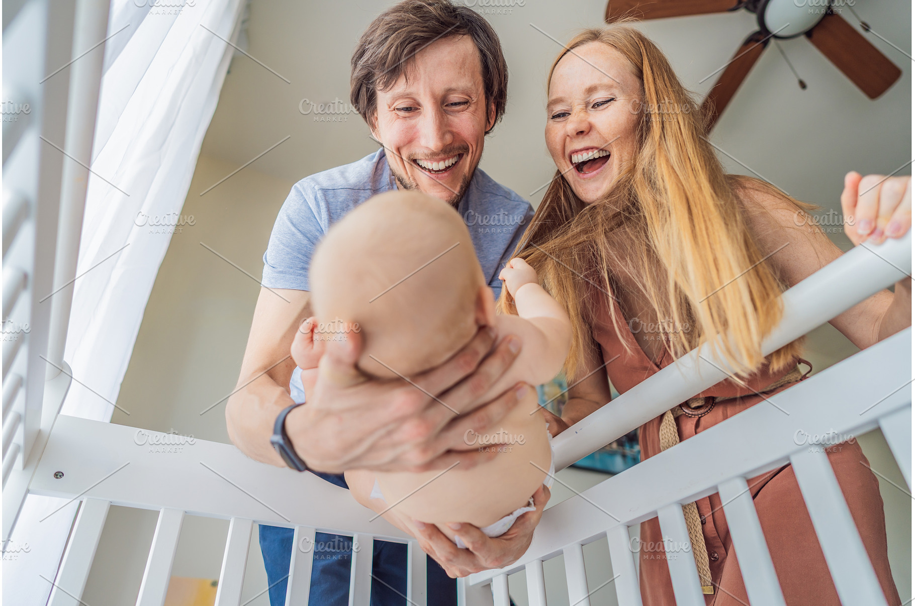 Mother and father lifting baby from, a Person Photo by Elizaveta Galitskaya