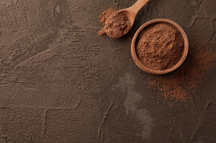 Bowl with cocoa powder and spoon on brown background, space for, a Food & Drink Photo by AtlasStudio