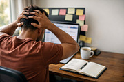 Man experiencing work stress at desk with computer and sticky no, a Photo by Dvoevnore photos (Thumbnail 2 of 2)