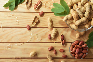 Bowls full of peanuts on wooden table decorated with leaves, a Food & Drink Photo by Davizro's Market