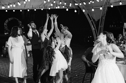 bride in a white dress throws a wedding bouquet