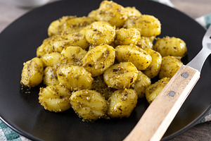 Gnocchi with pesto sauce served on black plate, a Food & Drink Photo by etorres69