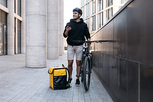 Smiling male courier standing, a Transportation Photo by Artem Varnitsin