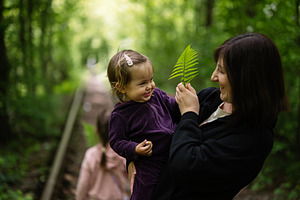 Mother and child enjoying nature while exploring greenery in a forest, a Photo by AS photostudio
